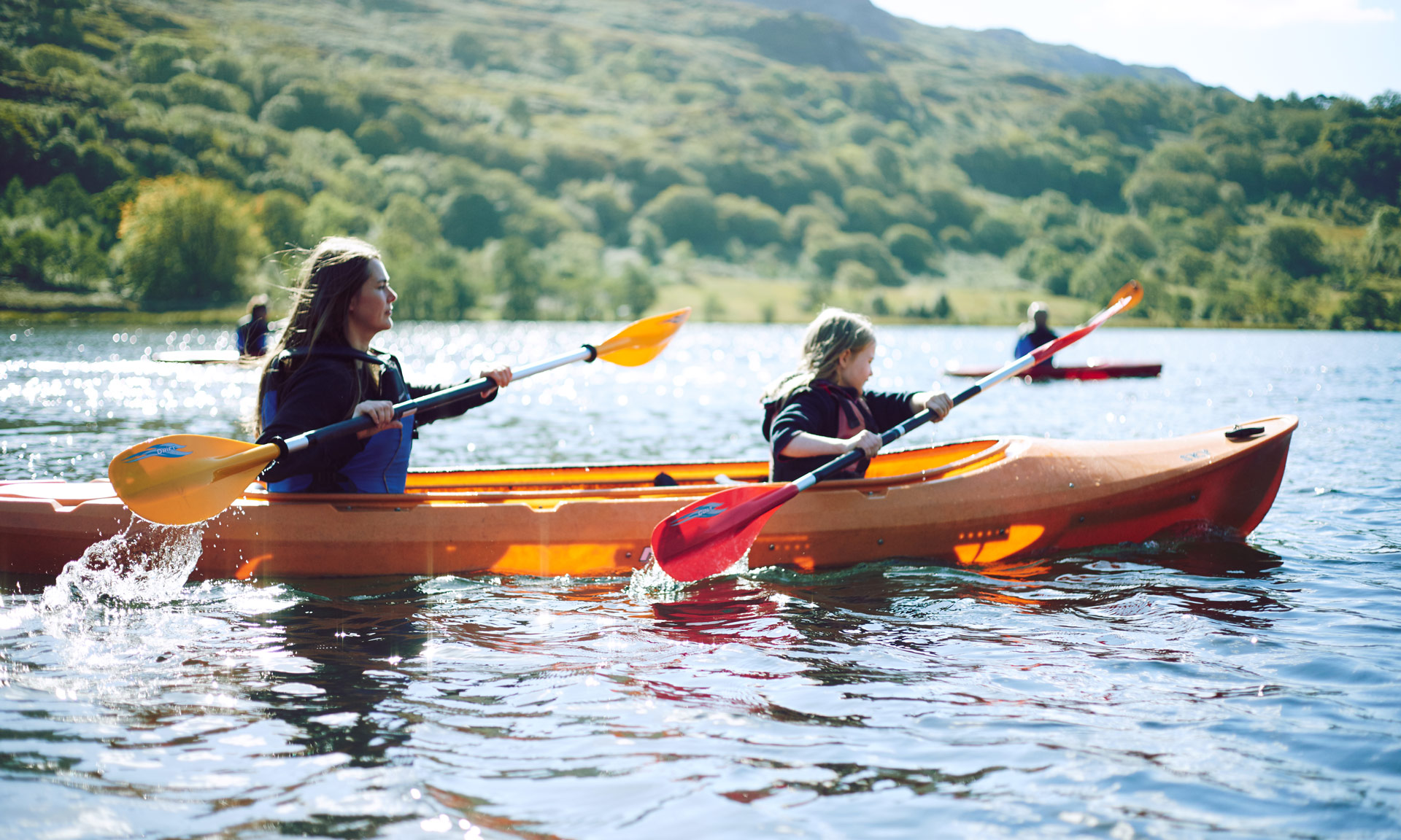 A woman and a child kayaks at Nant Gwynant