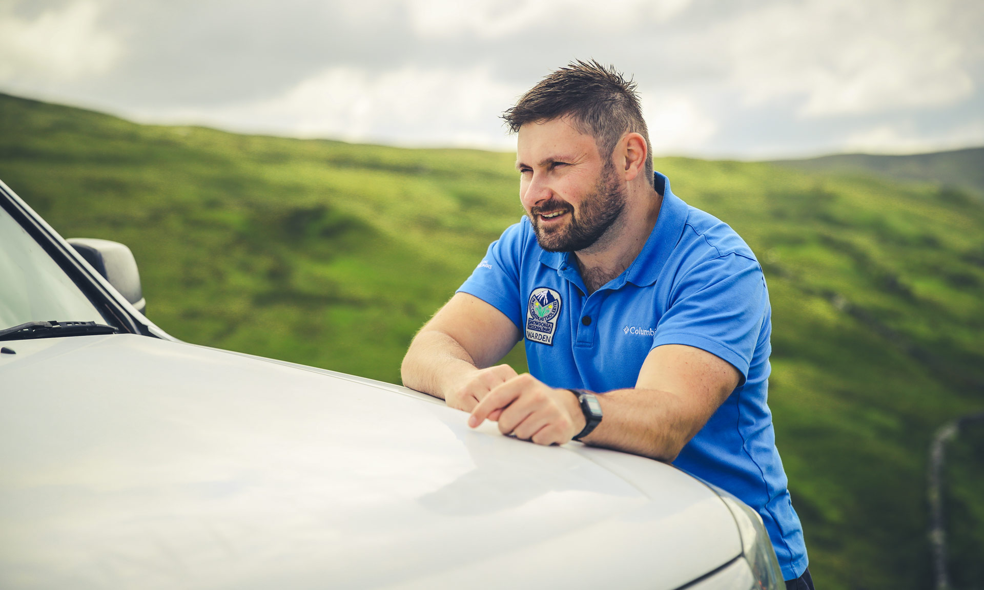 Eryri National Park Warden looking into the distance wearing his Eryri National Park poloshirt