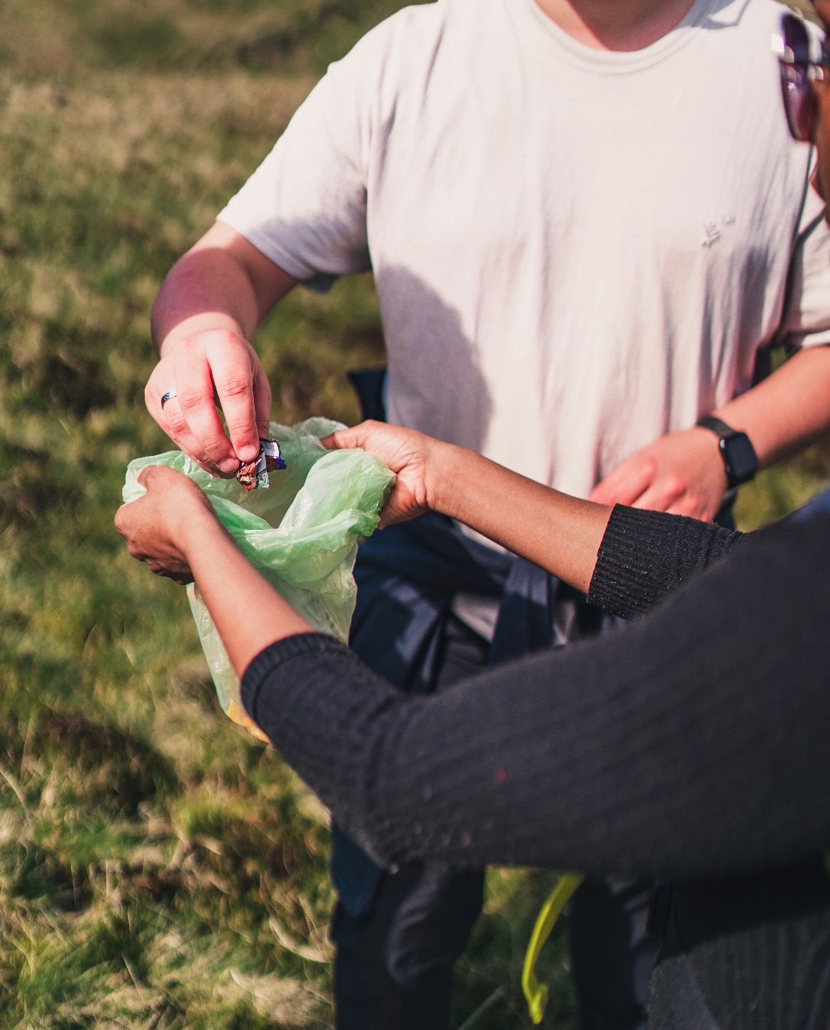 A person putting rubbish in a plastic bag