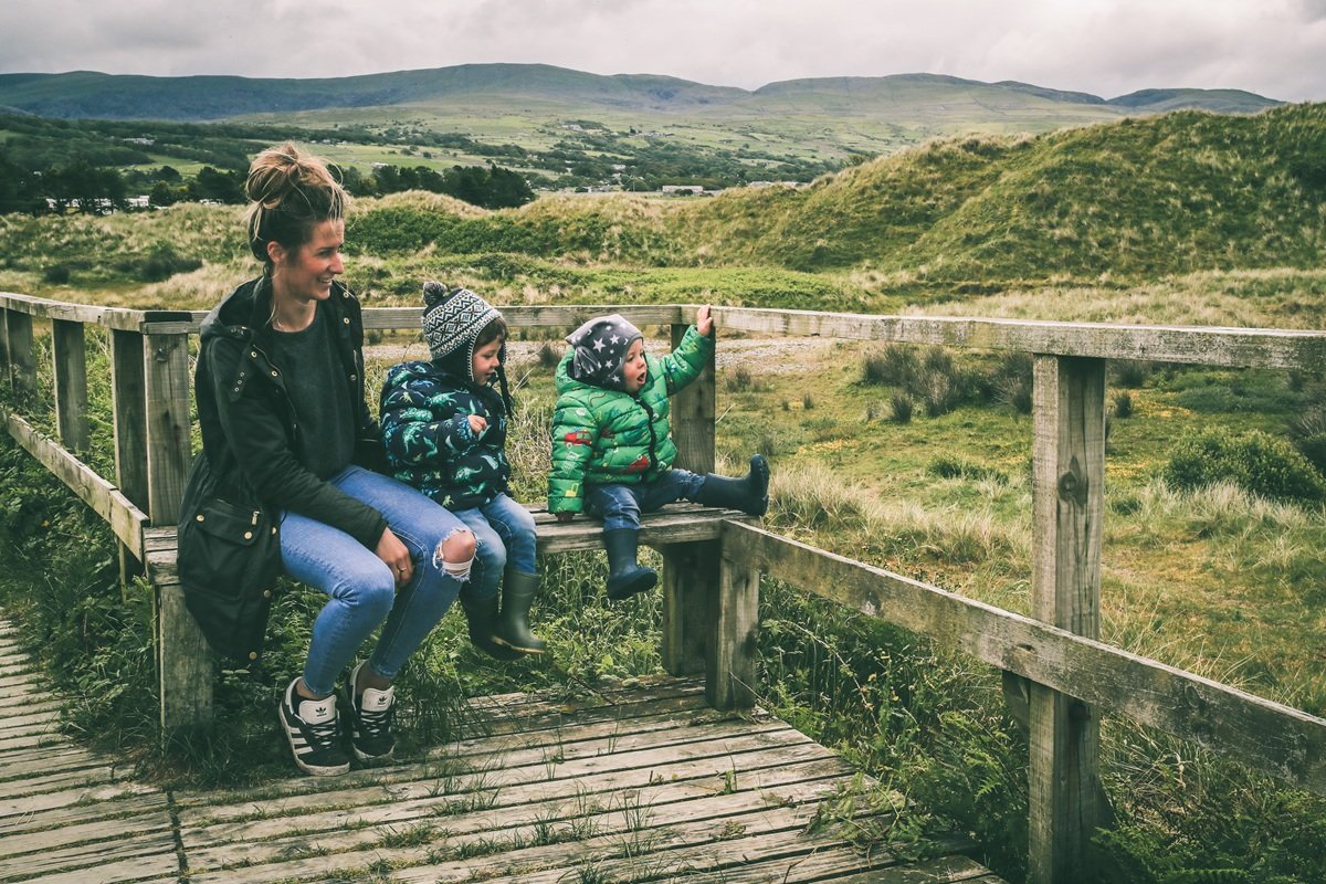 Mother and two boys sitting on the boardwalk